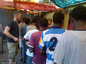 Migrants queue to get a hot meal: the project costs Mary around 180 euros a week to fund.