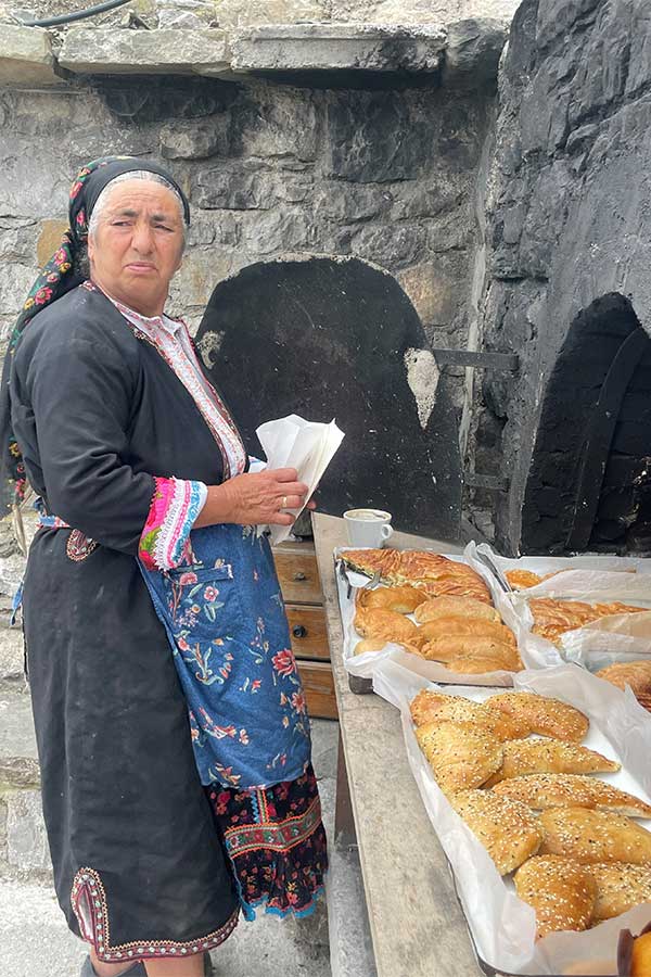 Local baker Kalliope, in traditional Karpathos costume, with her delicious pasties in the mountain village of Olympos