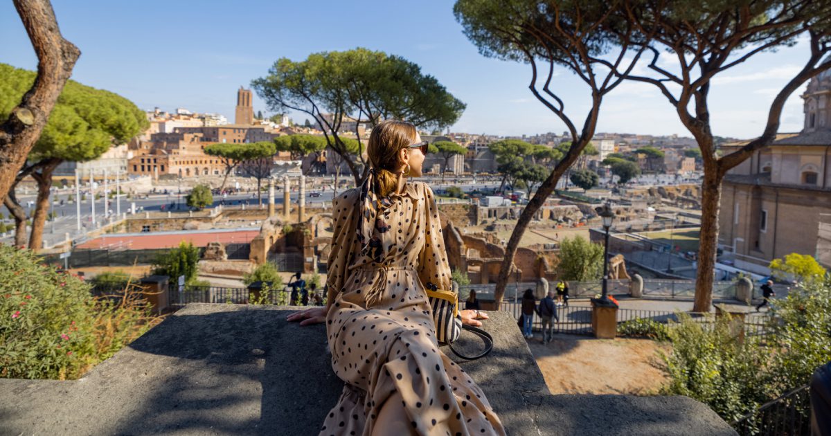 Woman enjoying beautiful view from above on the old centre of Rome | Solo Holidays to Italy for over 50s