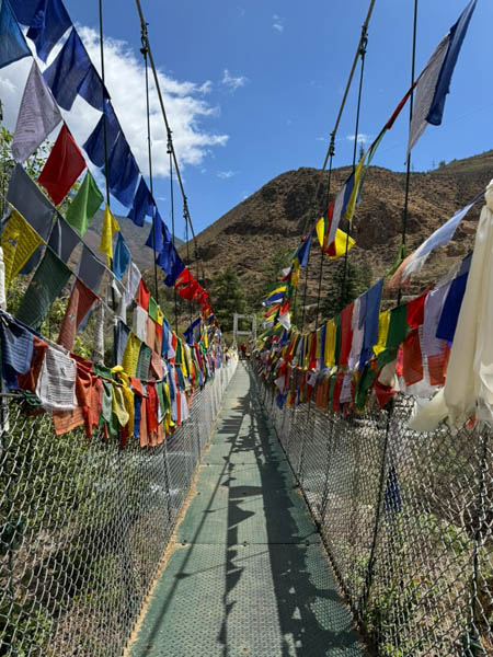 Prayer flags over a chain bridge