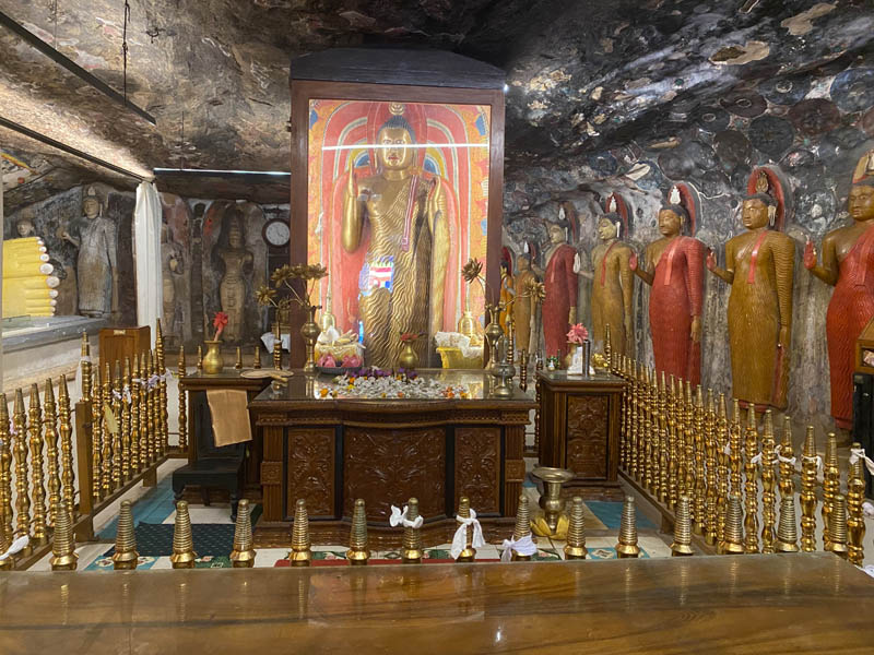 a buddha in a cave surrounded by other buddhas